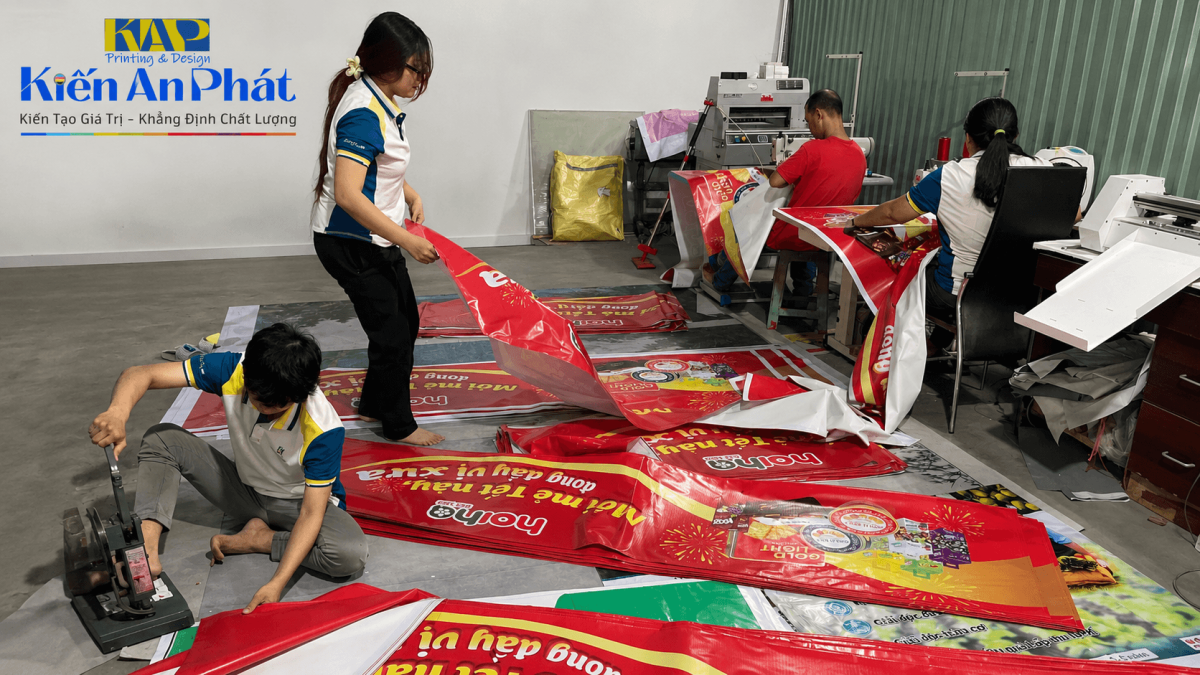 Thợ gia công dập khoen sắt mạ kẽm và dán mép bạt hiflex chắc chắn tại xưởng Kiến An Phát
